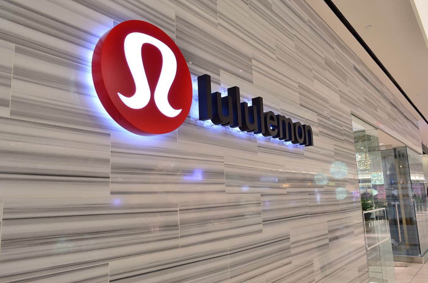 The lululemon mark lit up on a marble shopfront wall